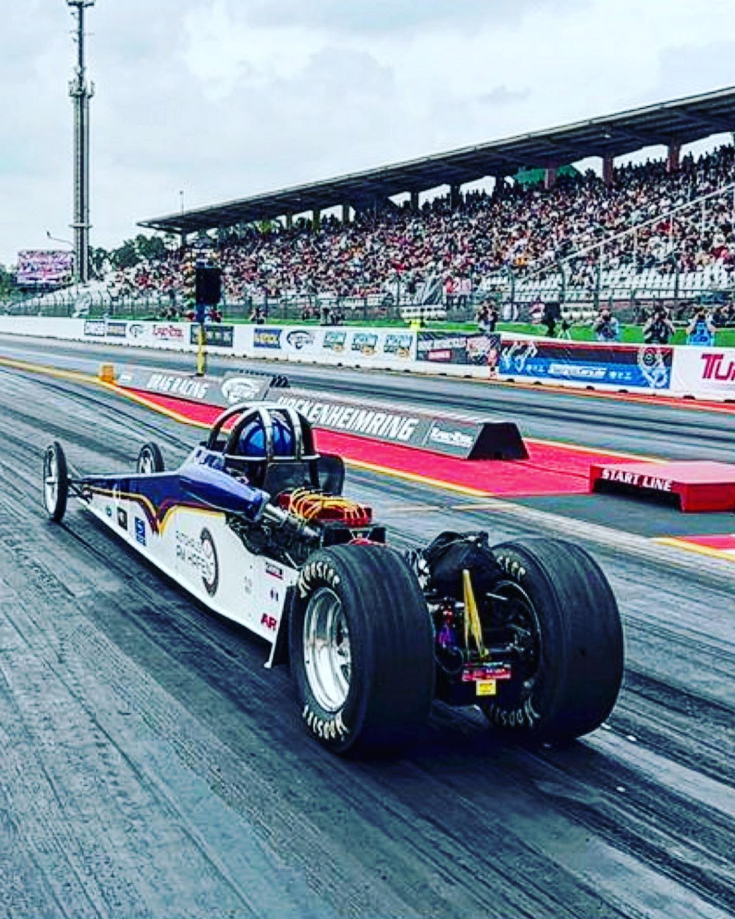 Dragster von Robin Sattler beim Start auf der Rennstrecke vor vollen Tribünen