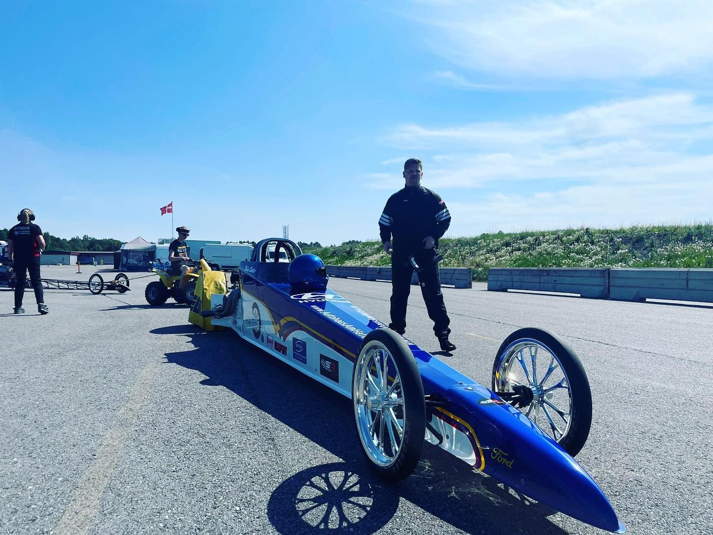 Robin Sattler neben seinem Dragster im Fahrerlager bei Sonnenschein